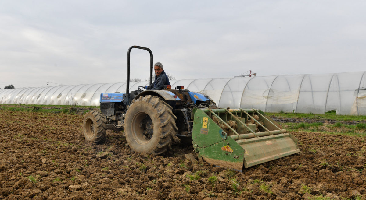 operatore agricolo che sovescia il terreno